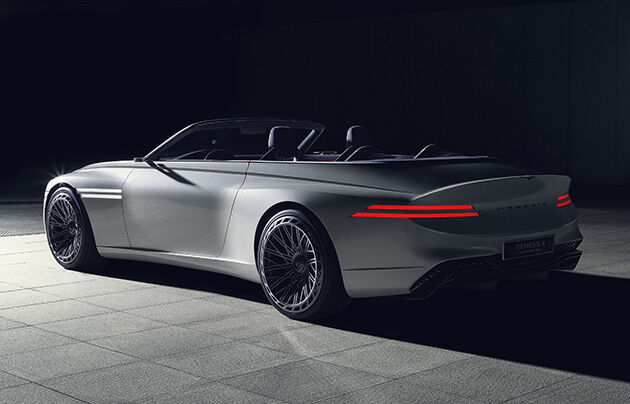 rear angle wide shot of a black genesis concept car, sleek coupe silhouette with butterfly doors opened, styled with rose gold alloy wheels.