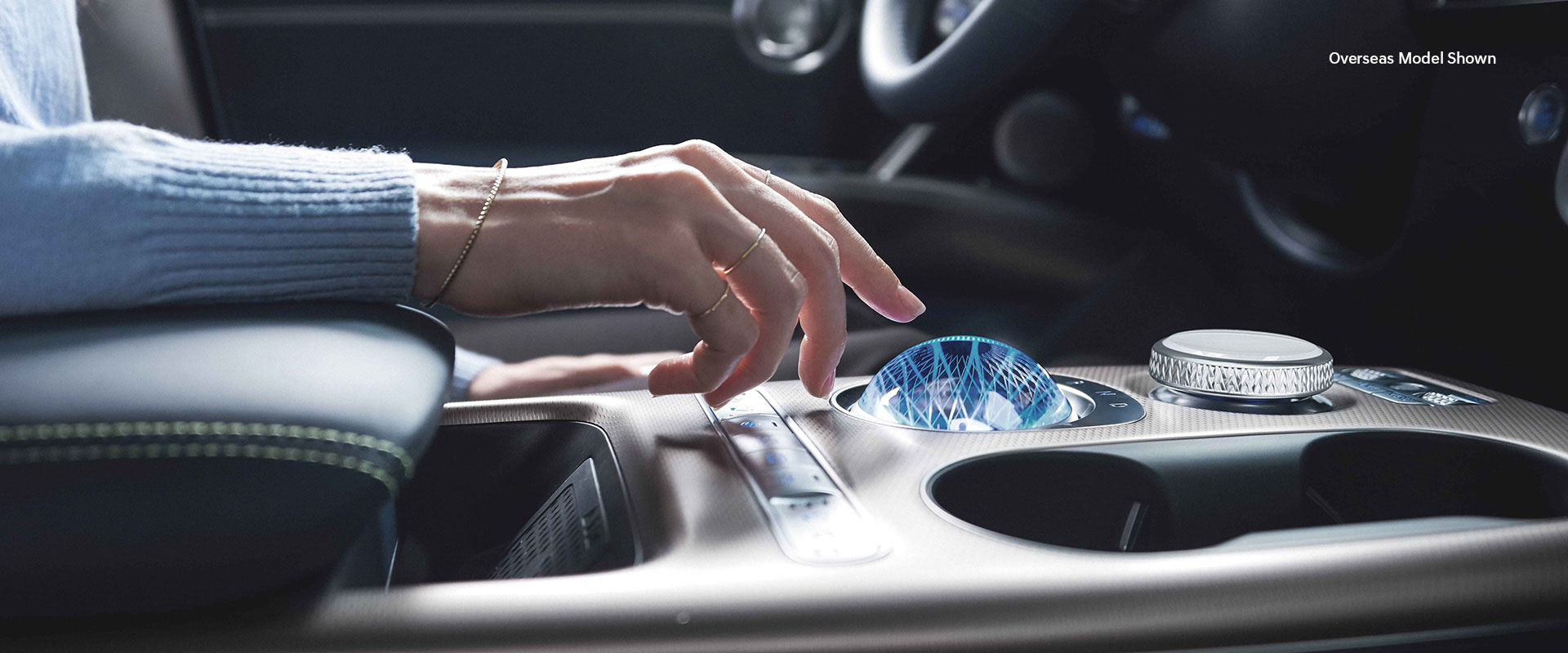 genesis gv60 crystal sphere image with talent's right hand hovering over.