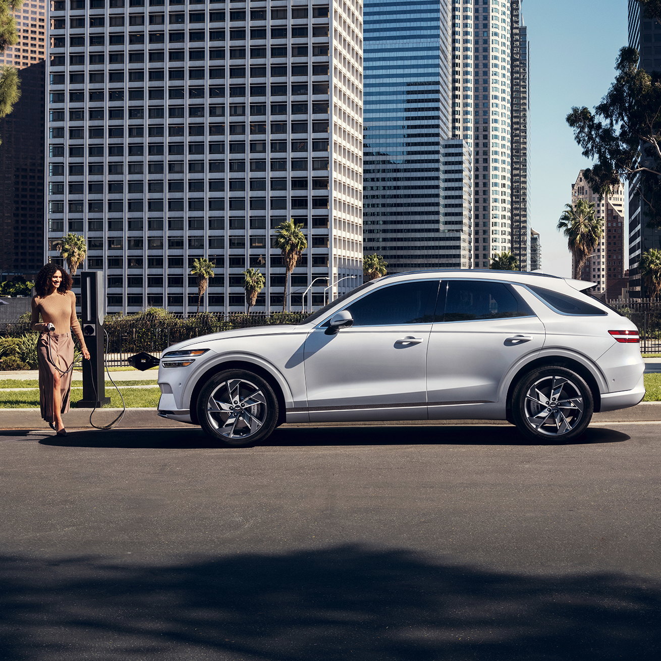 Woman beside White Electrified GV70