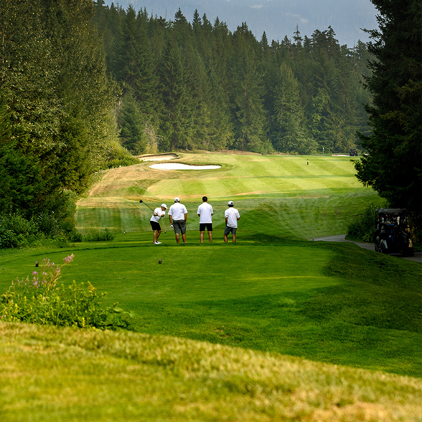 4 men standing on a golf course