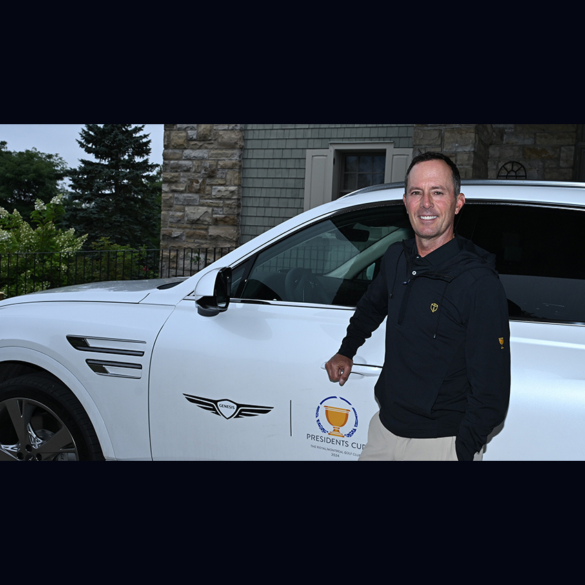 Mike Weird standing in front of a white Genesis GV70