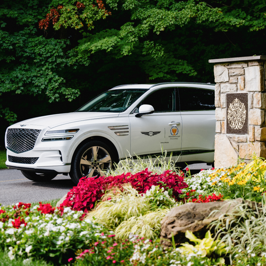 Two Genesis SUVs parked in front of the Royal Montreal Golf Club