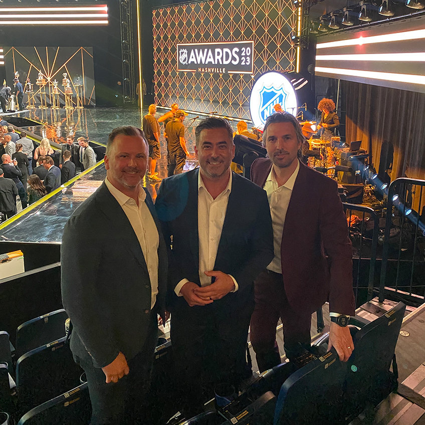 Three men standing in front of the stage at the NHL Nashville Awards