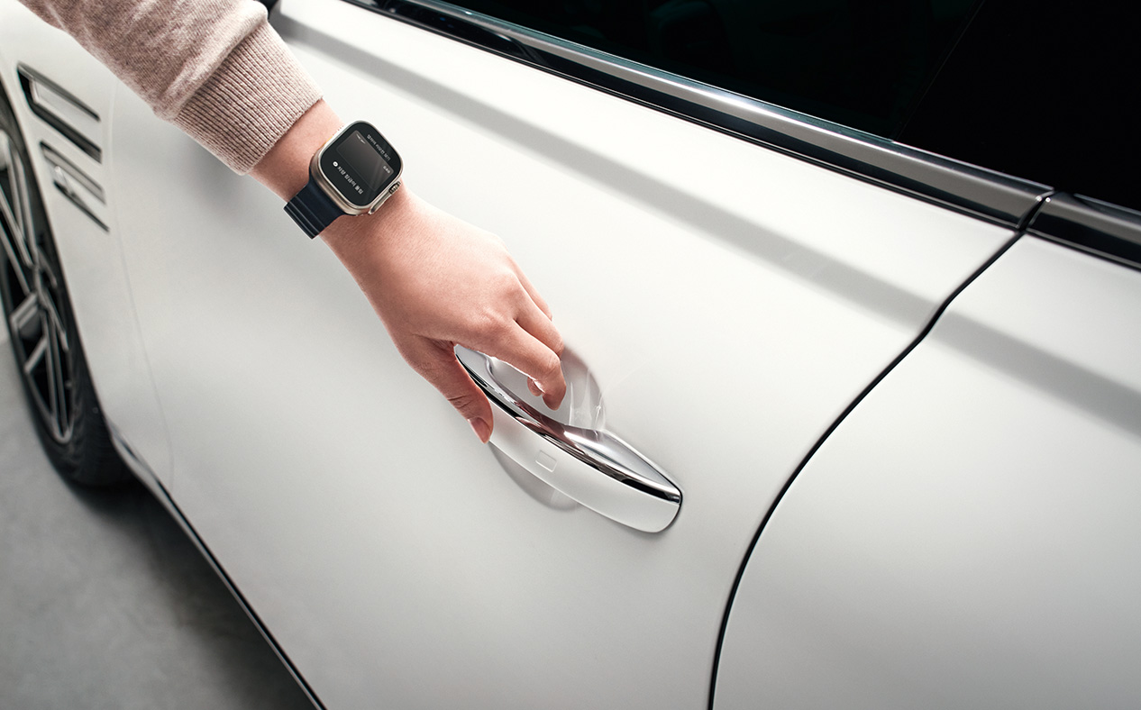 The driver touches their apple watch to the door handle.