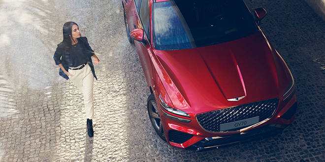 Femme se tenant à côté d’un Genesis GV70