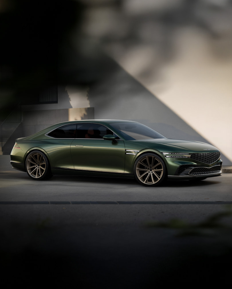 Against a shadowy wall, the Genesis X Gran Coupe Concept is parked on its left side.