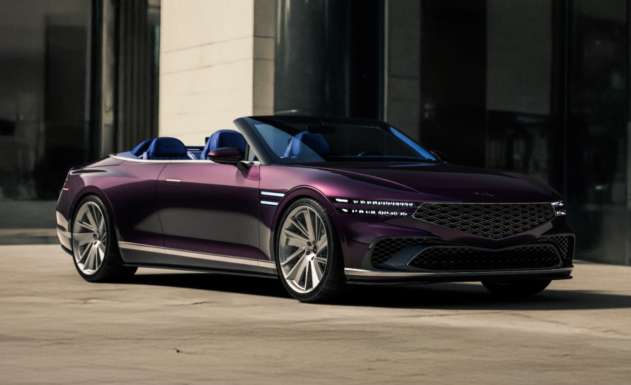 With a modern building in the background, the Genesis X Gran Convertible Concept is parked facing right.