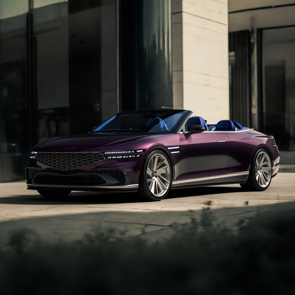 With a modern building in the background, the Genesis X Gran Convertible Concept is parked facing right.
