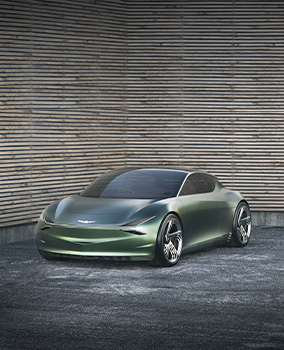 The Genesis Mint concept car is parked diagonally in front of a wall with a unique texture.