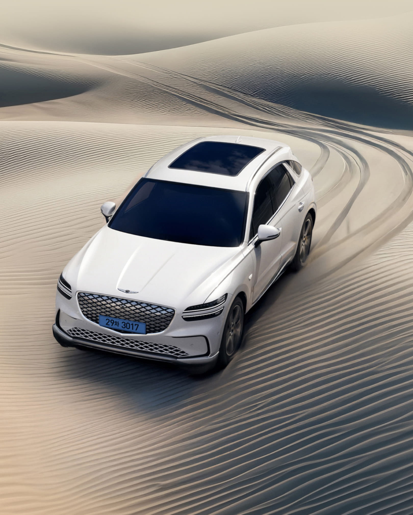 The Electrified GV70 drives in a desert.