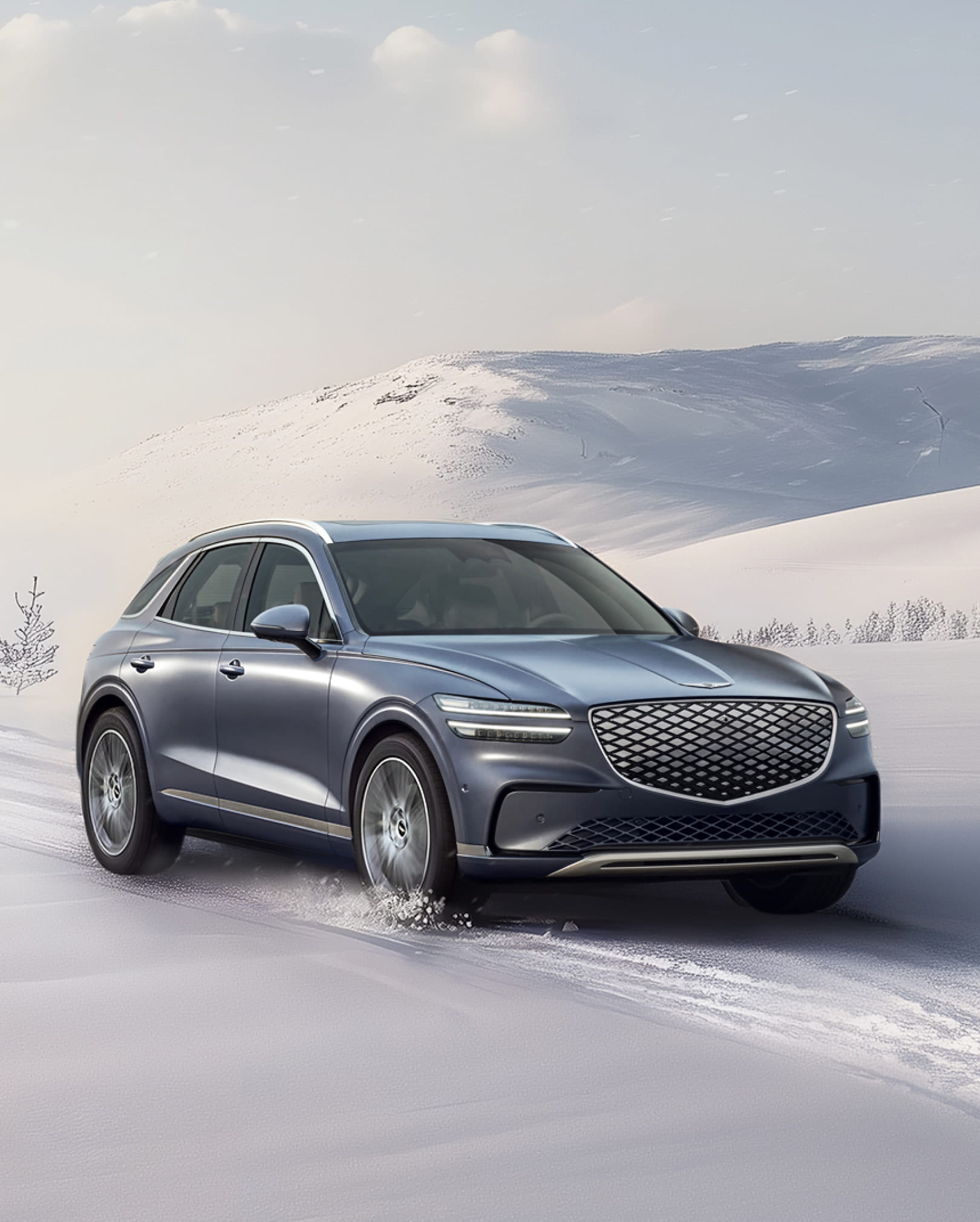 The Electrified GV70 drives on a snowy road.