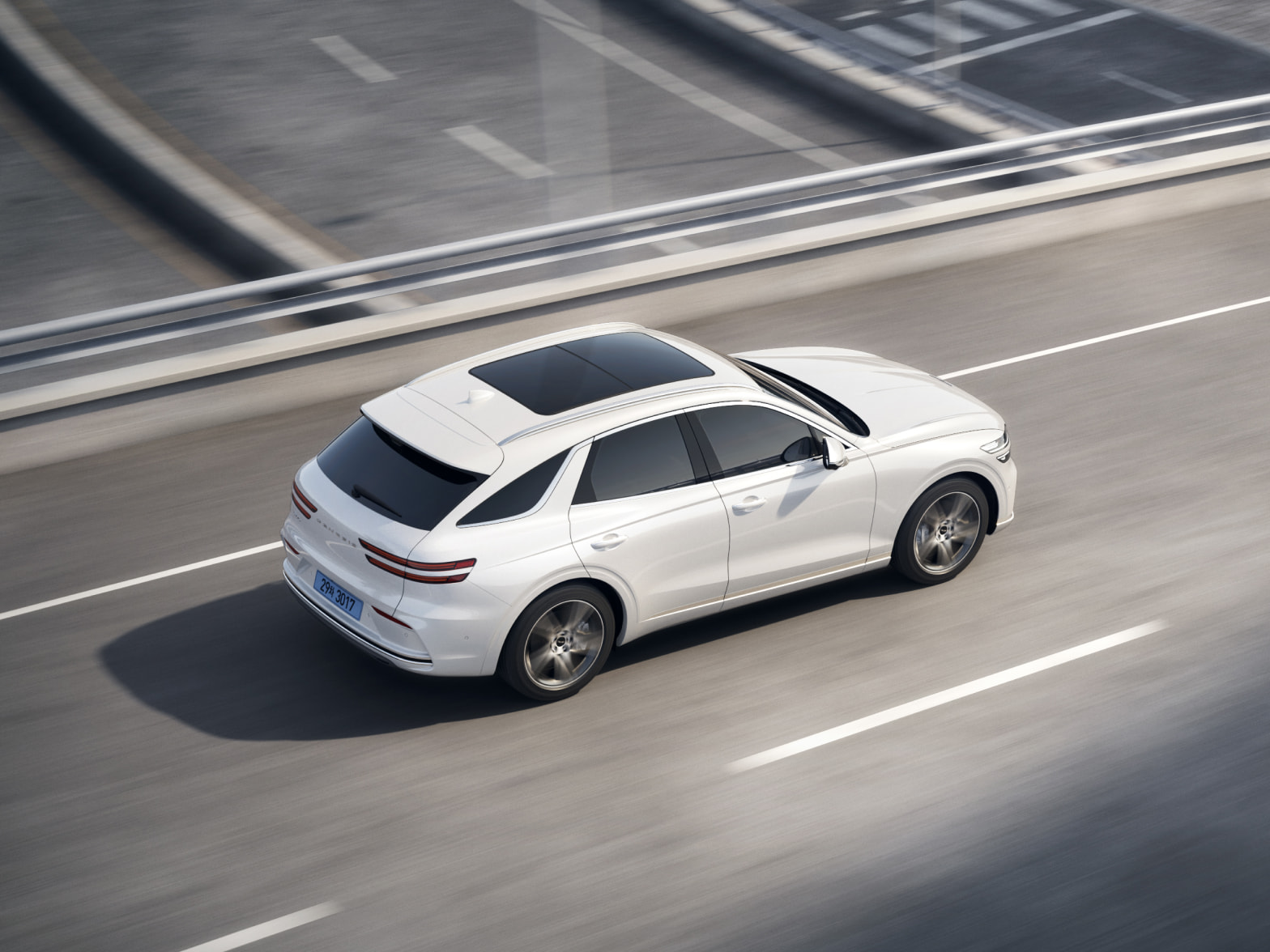 An aerial view of the right side of the vehicle as it drives down the road.
