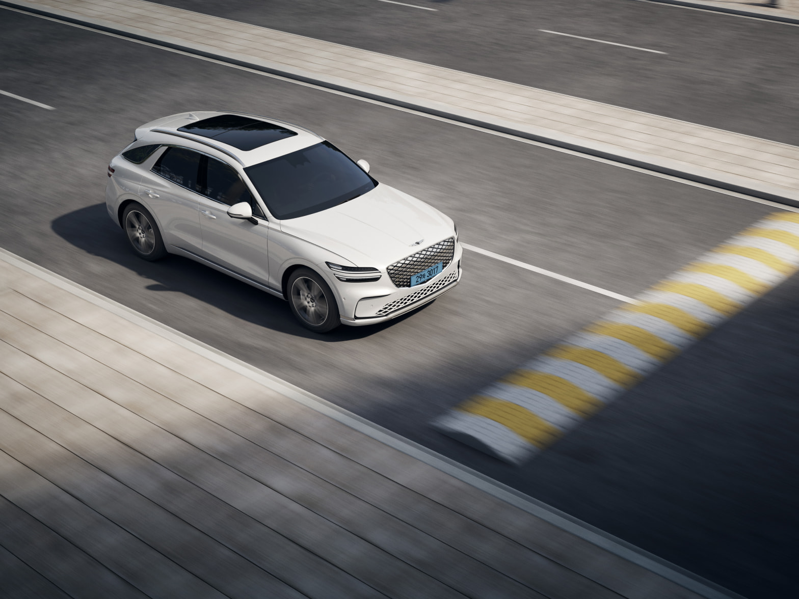 The Electrified GV70 approaches a speed bump as it travels down the road.