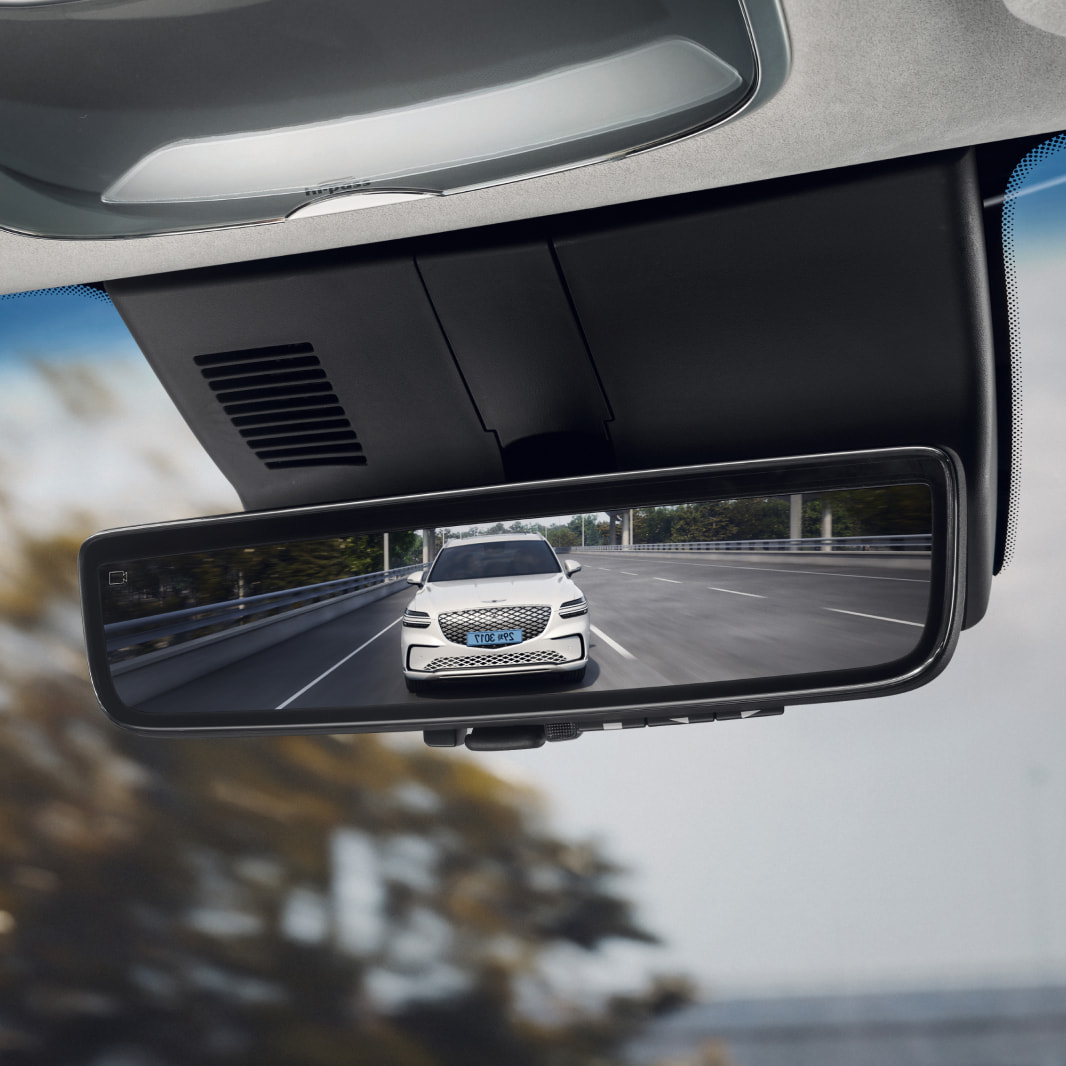 In the vehicle's rearview mirror, another vehicle from behind can be seen.