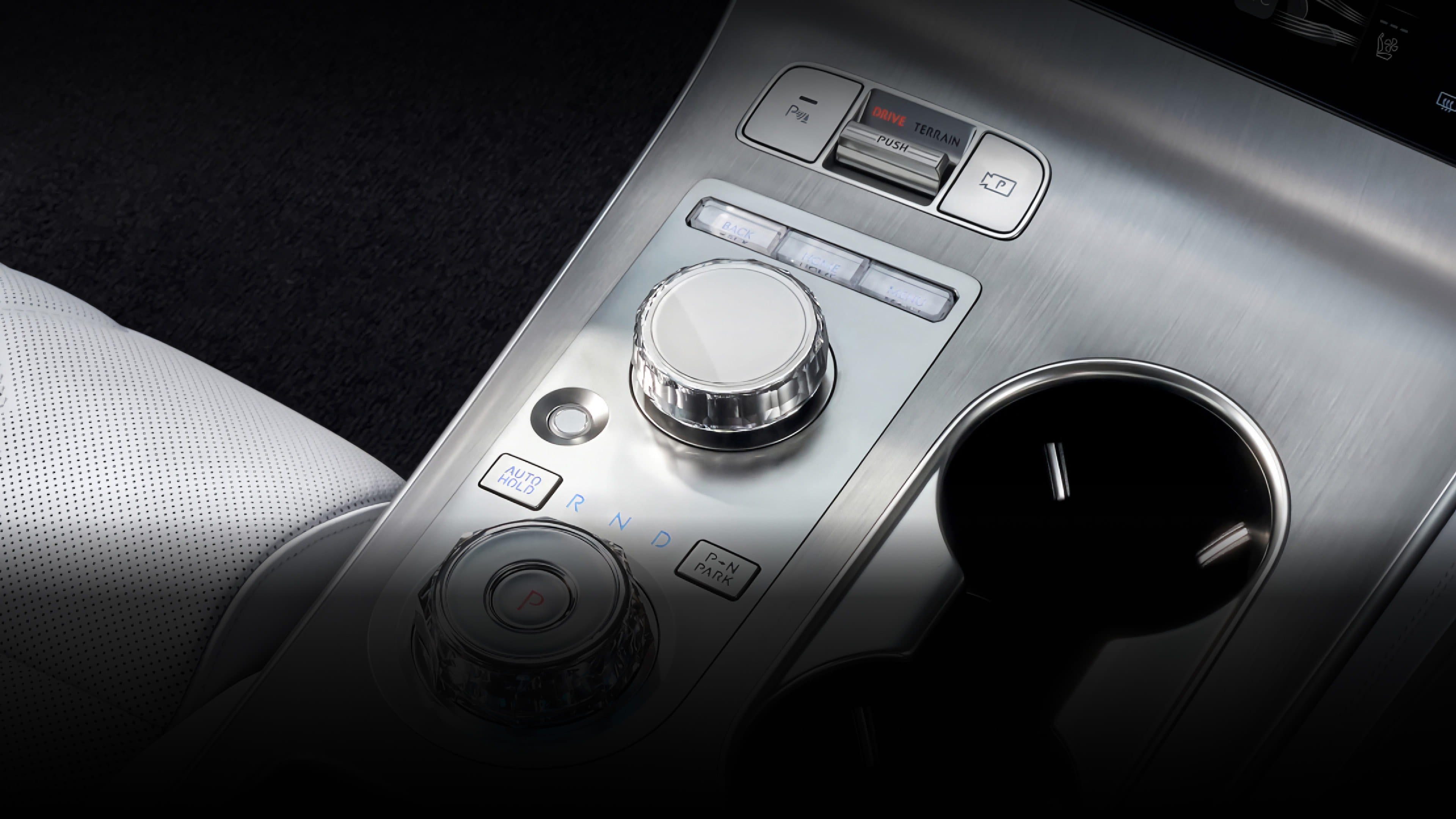 A view of the integrated controller between the driver and front passenger seats, featuring various control buttons and dials.