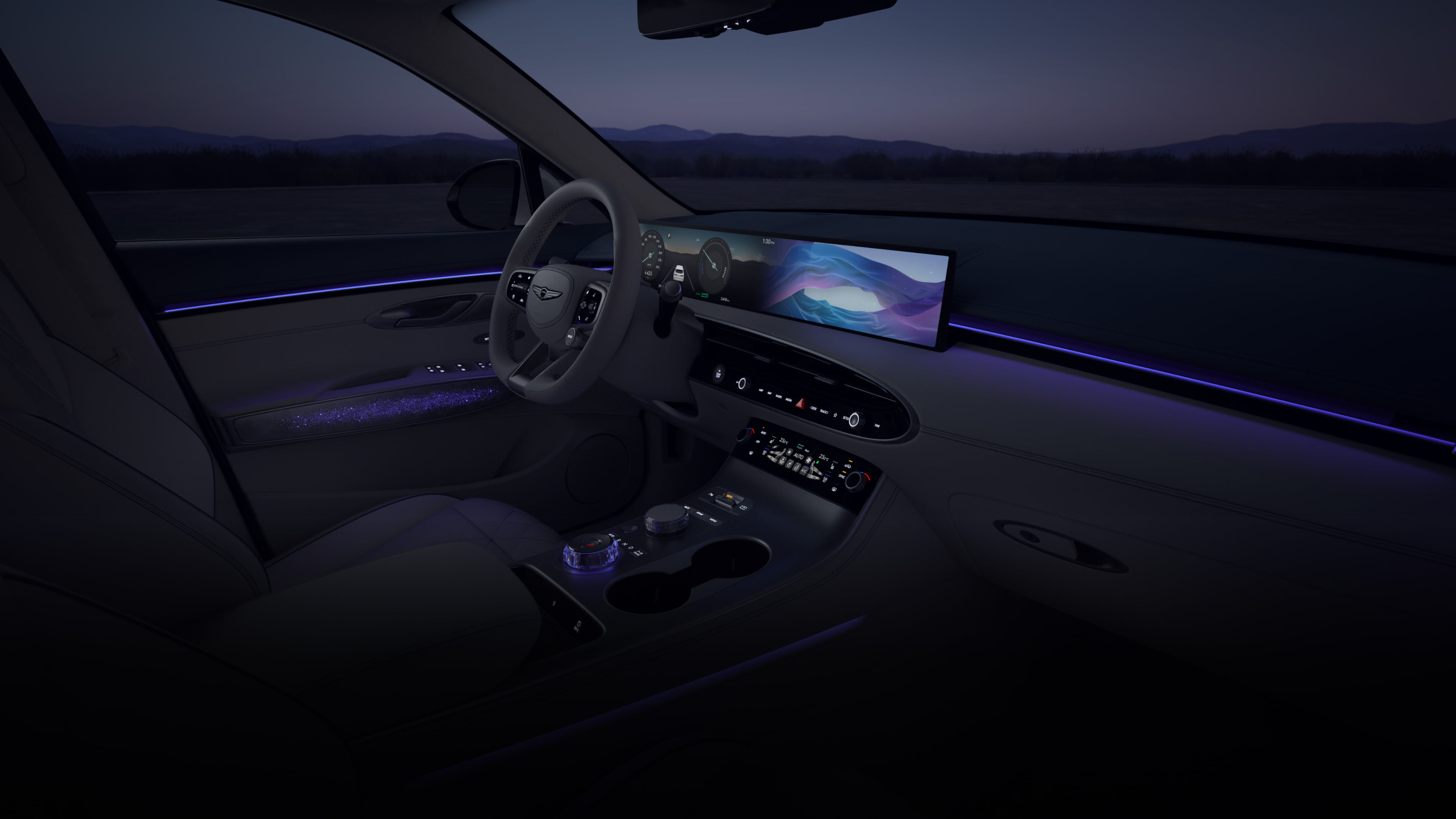 A wide-angle view of the driver's seat from the front passenger's seat. A vibrant array of colorful graphics cycle on the wide display screen in front of the driver’s seat. As the colors on the display shift, so does the ambient lighting of the vehicle's interior. 