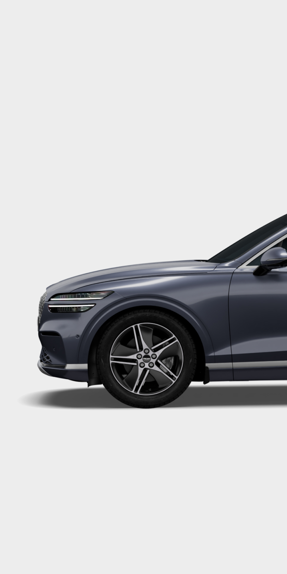 The side view and wheel of the Electrified GV70 in Ceres blue exterior color is visible.