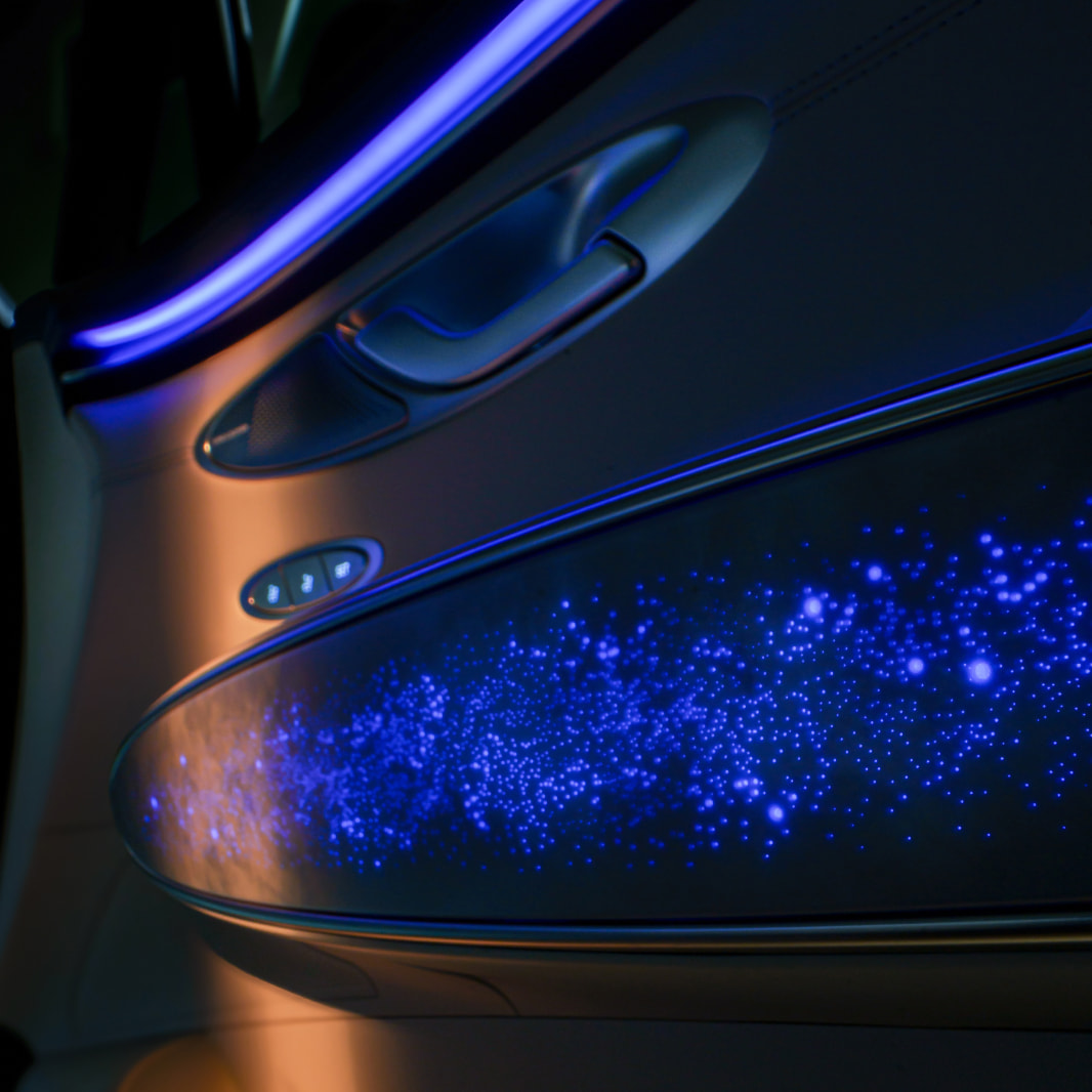 Atmospheric blue mood light illuminates the area beneath the door handle on the front passenger side.