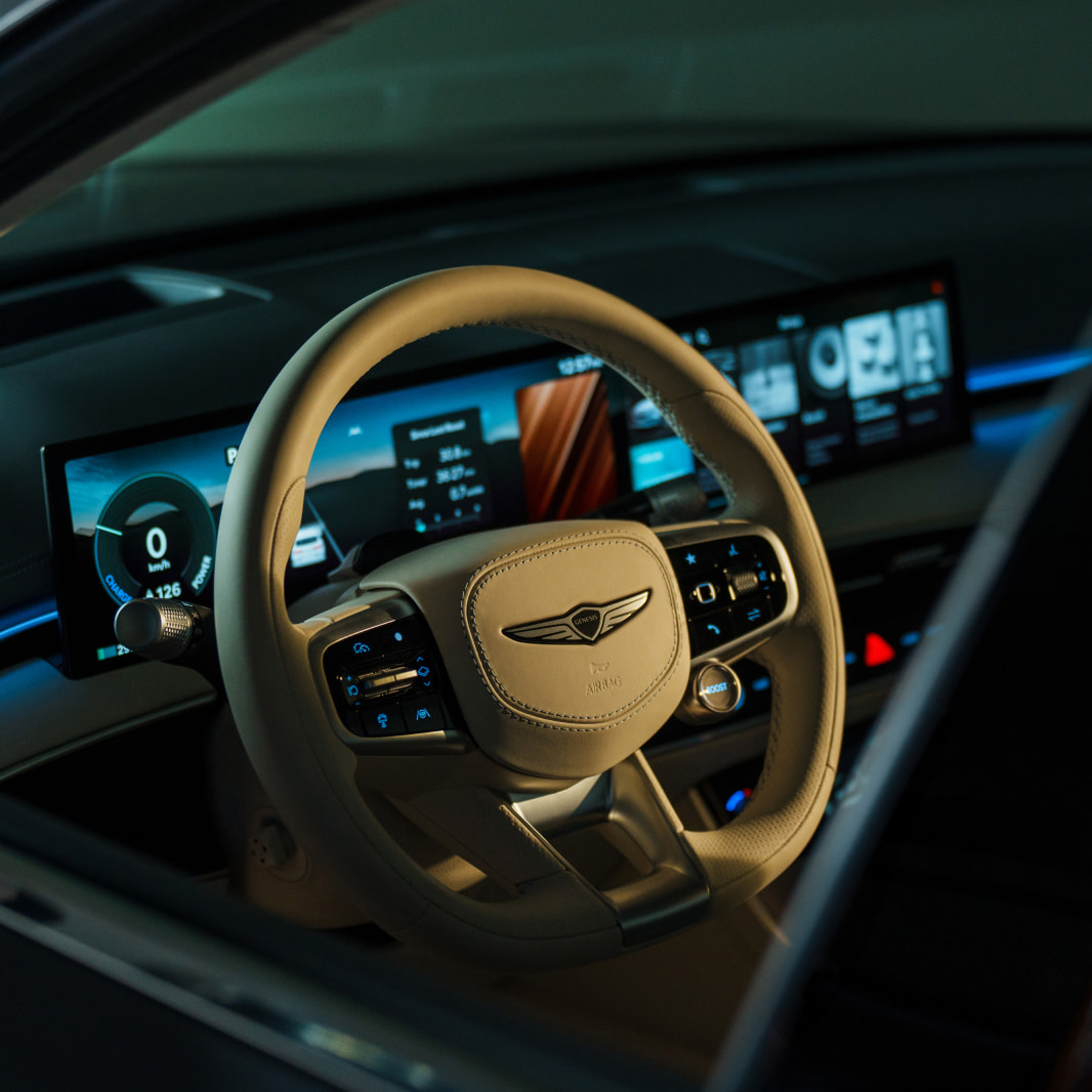 A view inside the dark interior of the parked vehicle, with only the steering wheel and display illuminated.