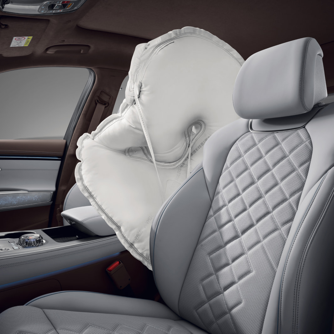 A white airbag is deployed between the driver and front passenger seats.