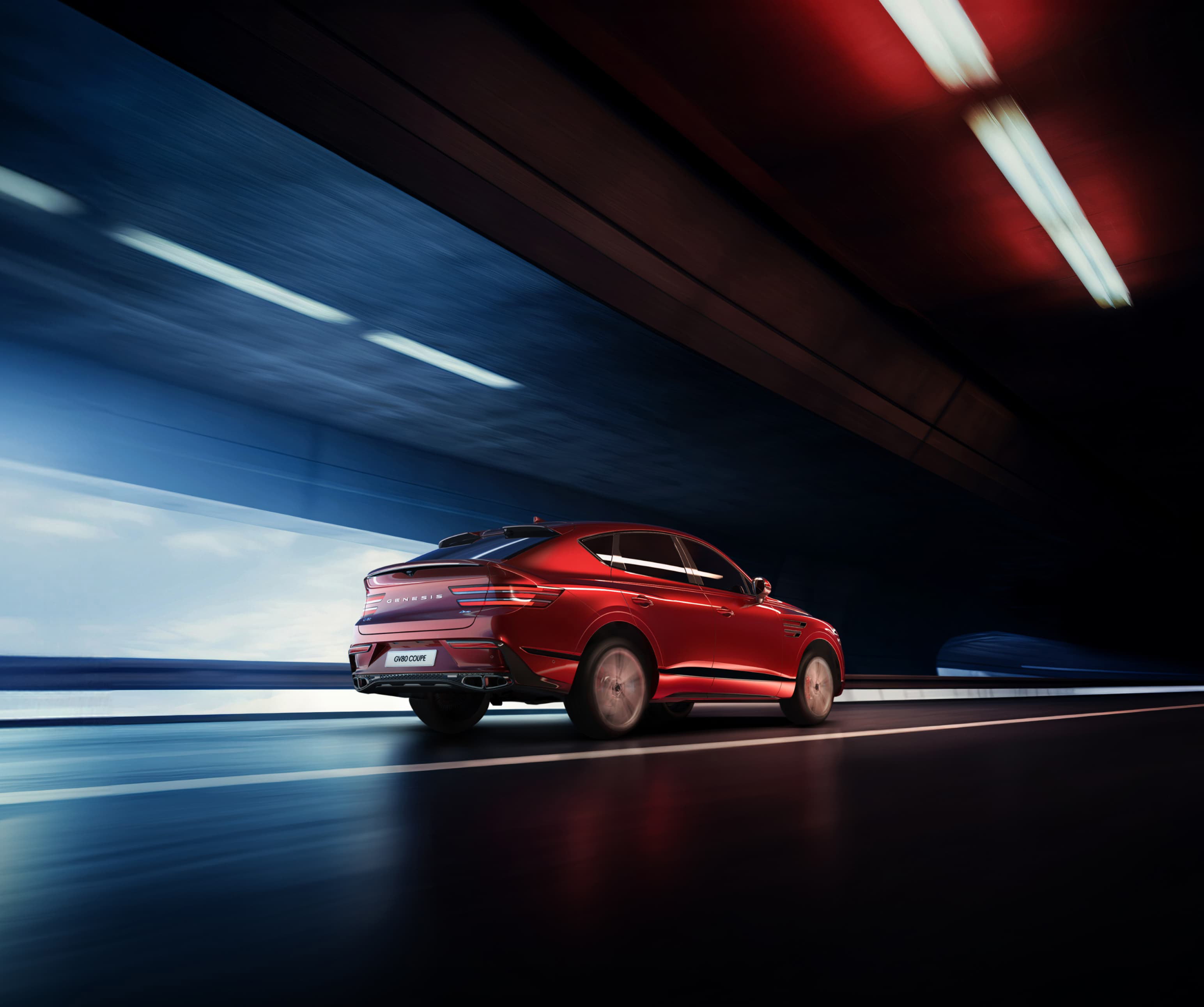 Mauna Red GV80 Coupe driving quickly through a tunnel.