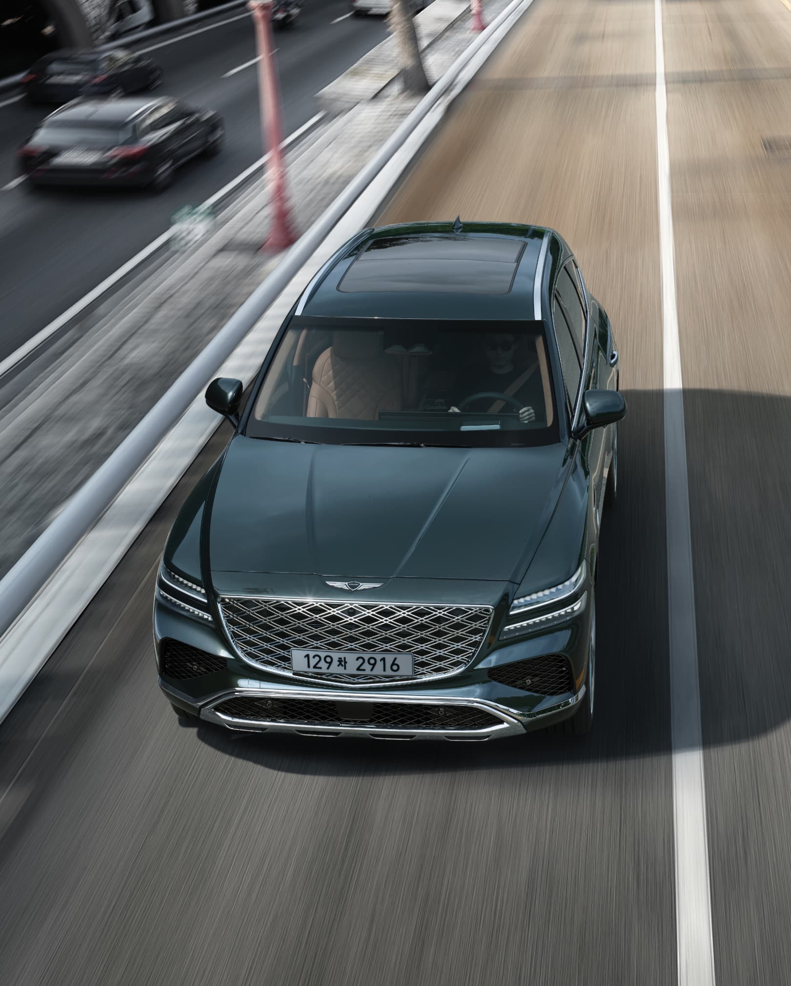 Storr Green GV80 Coupe driving on the highway.