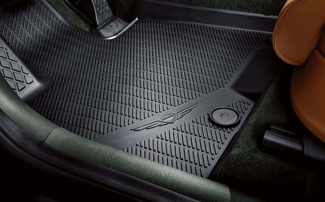 There is a diagonal pattern protection mat on the driver's seat floor, next to the accelerator and brake pedals.