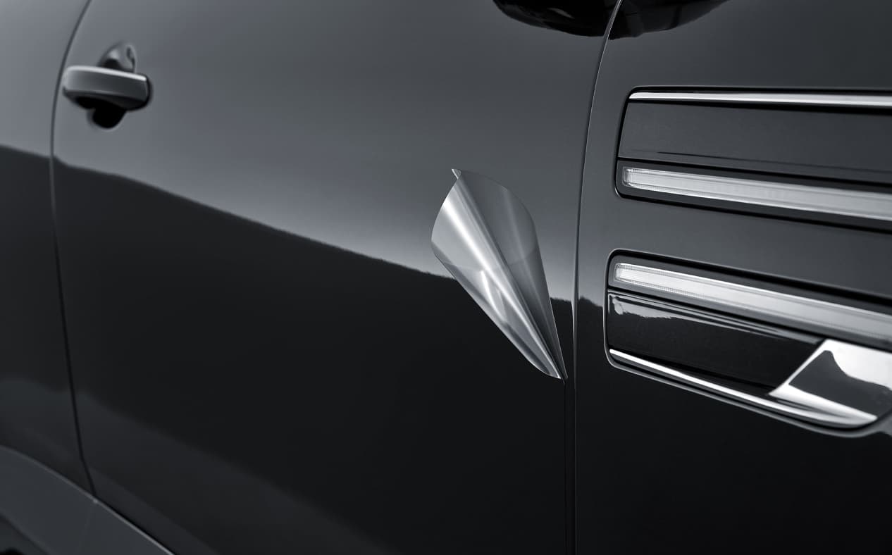 Slightly rolled-up transparent film next to the Two Lines lights on the driver's side of the Vik Black GV80 Coupe.