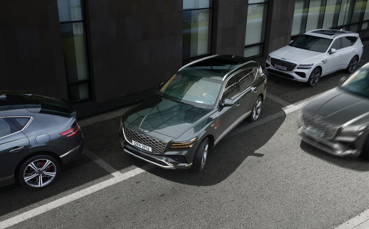 Storr Green GV80 Coupe is pulling out from a building's parking lot.