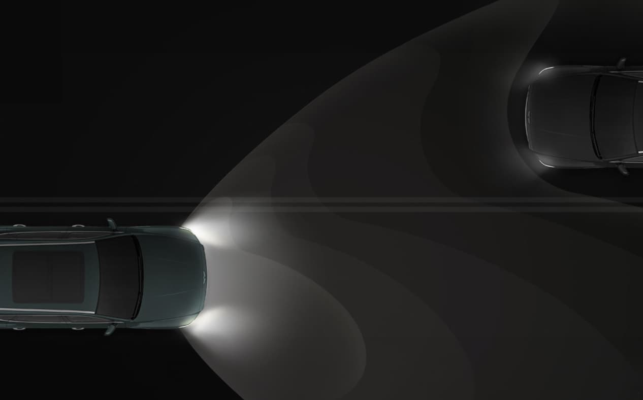 GV80 Coupe driving on a dark road with the headlamps turned on.