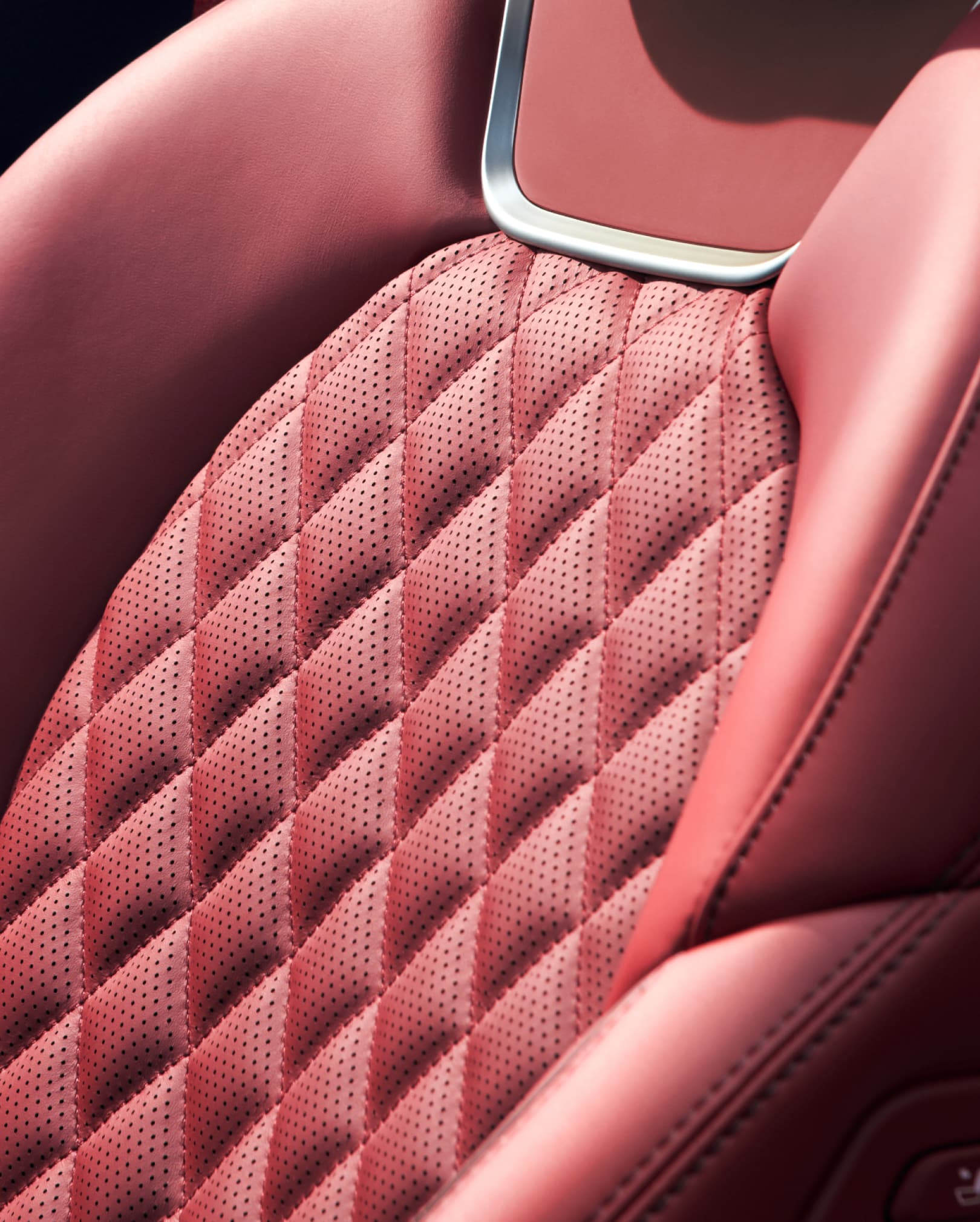The leather seats with piping seen from the front in the first row of the G70 Shooting Brake, in the Obsidian Black/Sevia Red Two-tone color.
