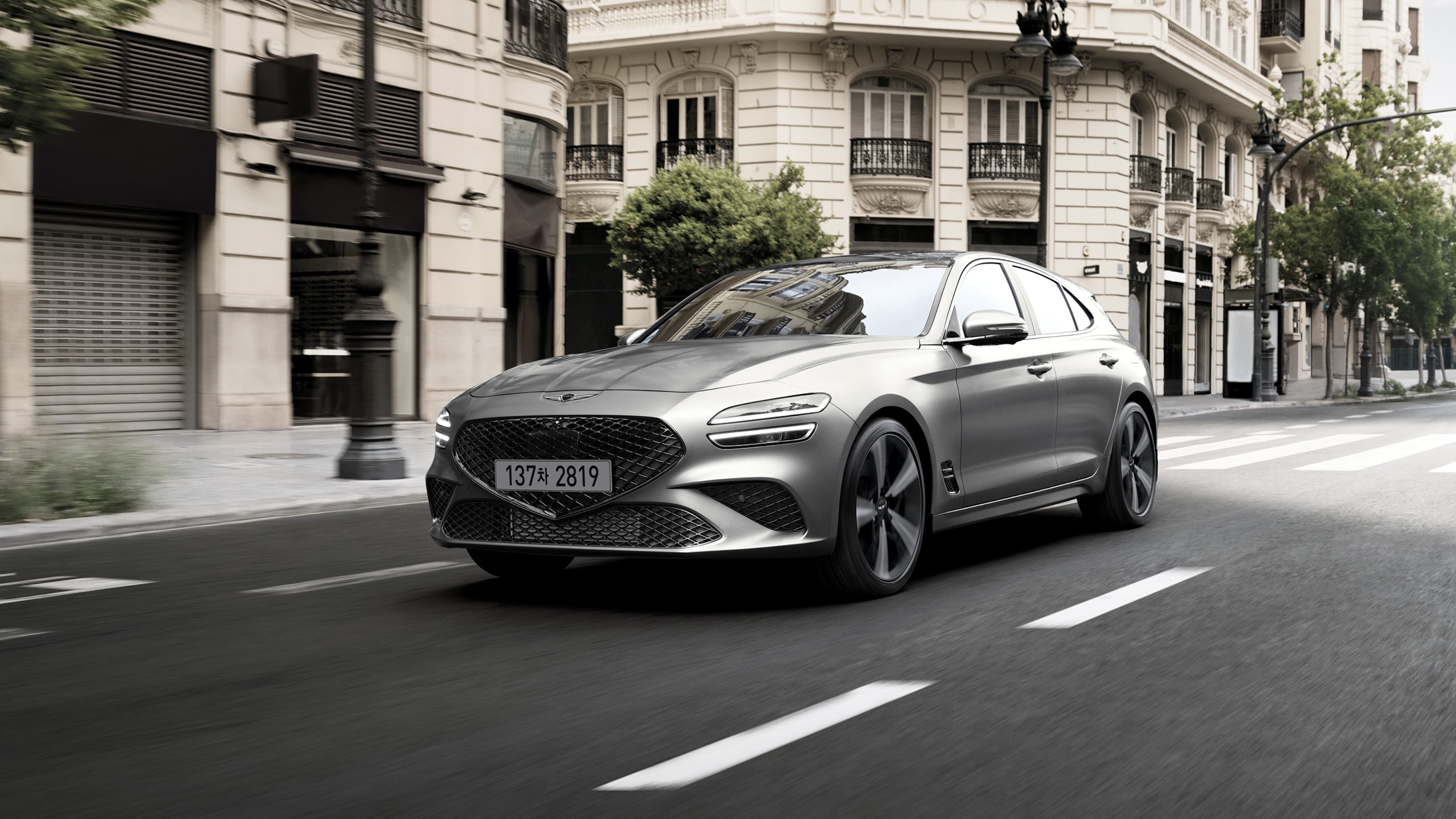 The Savile Silver G70 Shooting Brake driving in the city is followed by a Makalu Gray G70 Shooting Brake, and finally, the front of the Cavendish Red-colored G70 Shooting Brake Sports model.