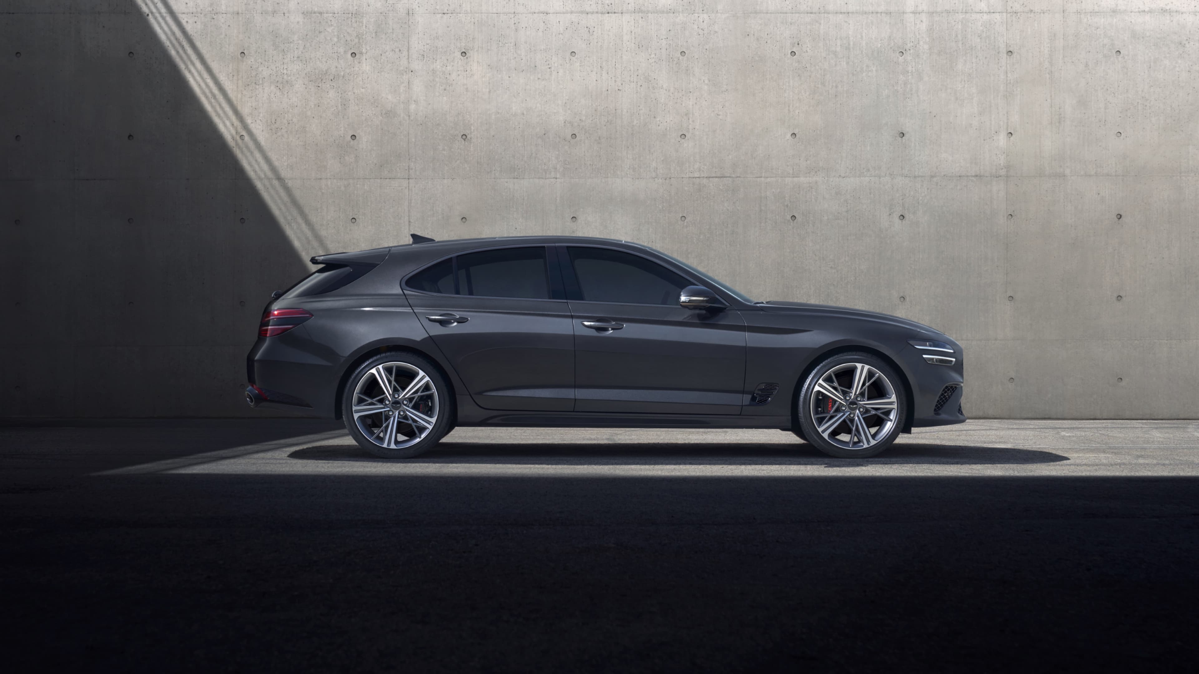 The Savile Silver G70 Shooting Brake driving in the city is followed by a Makalu Gray G70 Shooting Brake, and finally, the front of the Cavendish Red-colored G70 Shooting Brake Sports model.