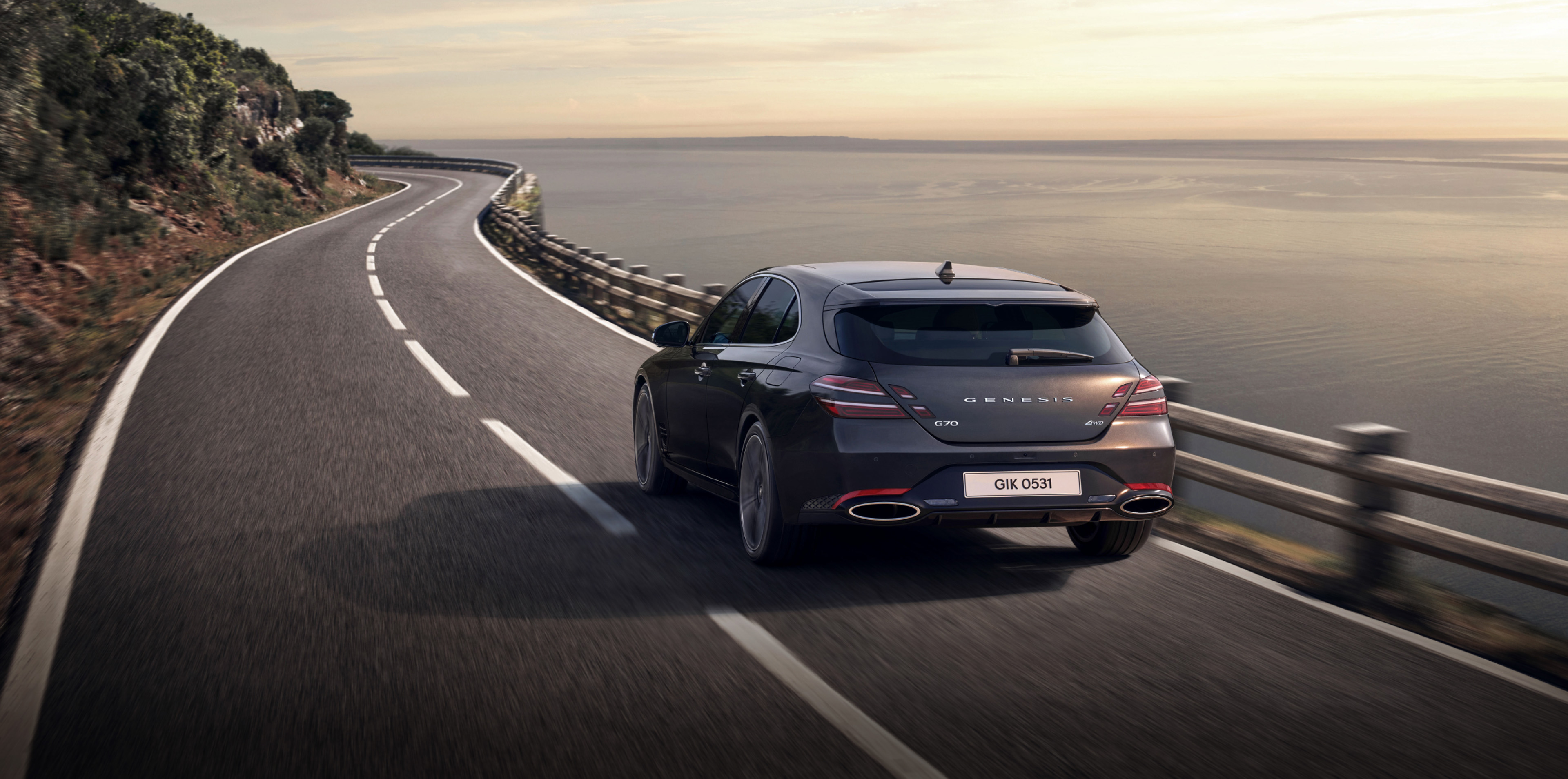 G70 Shooting Brake in Makalu Gray is driving on a coastal road.
