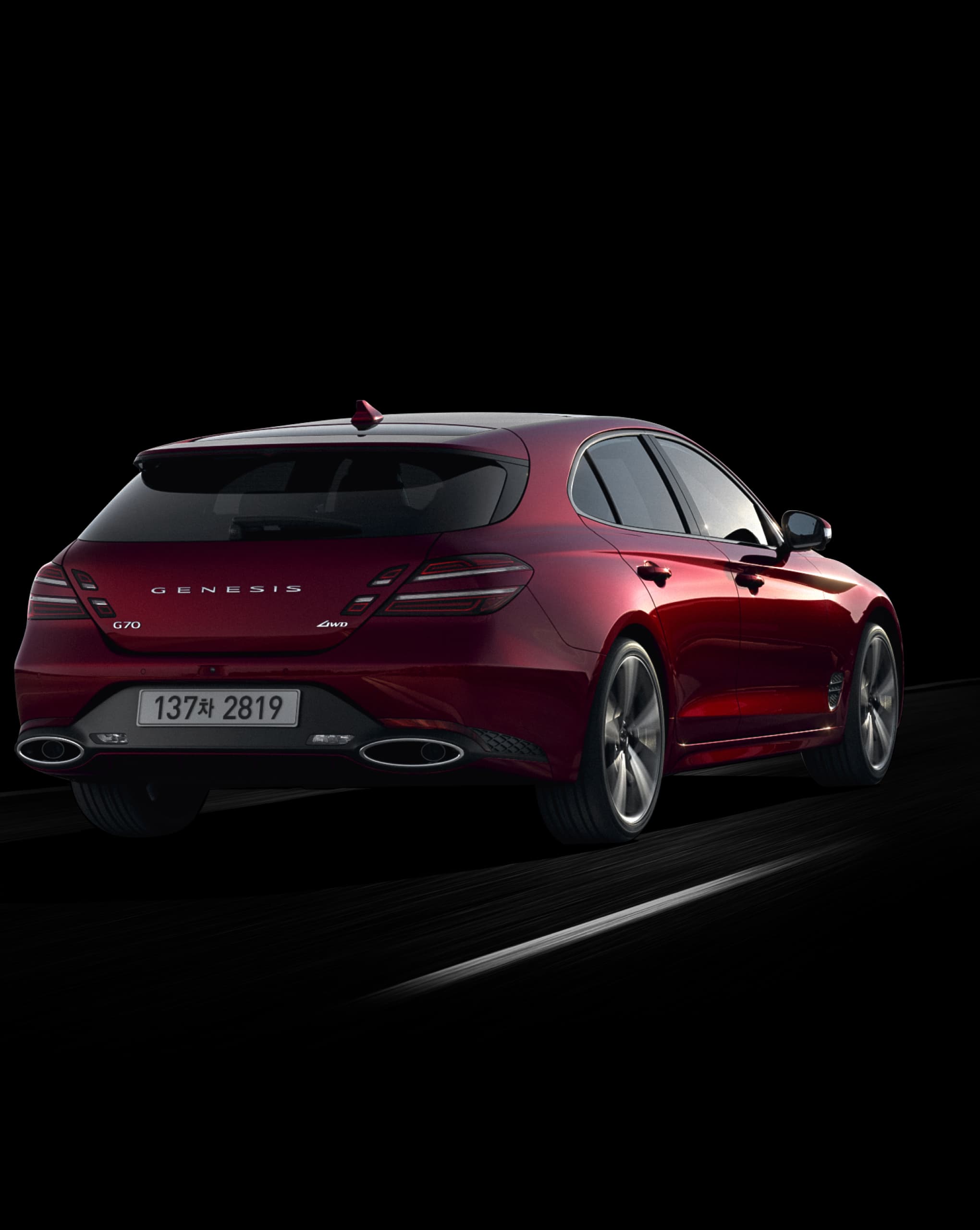 This is the rear view of the Cavendish Red G70 Shooting Brake vehicle driving on the road.