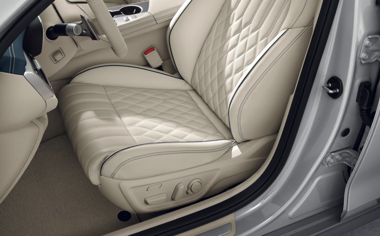 The right door of the first row is open, and the G70 Shooting Brake's intelligent seat and smart posture control system is seen, in Forest Blue/Vanilla Beige Two-tone.