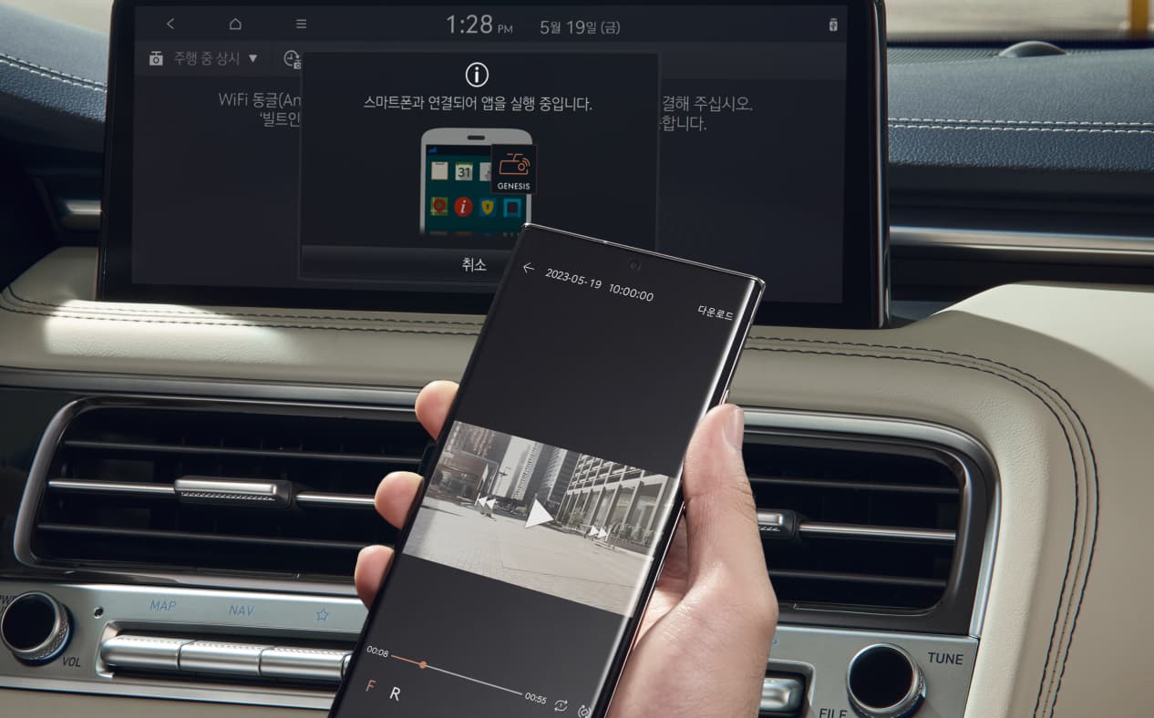 Driver holds a smartphone and plays back the video recorded by the car camera.