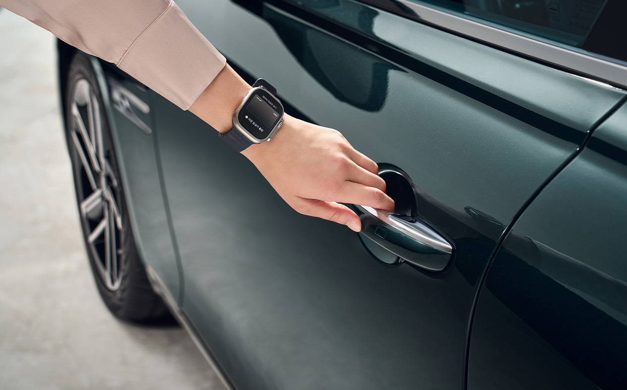 The driver touches their apple watch to the door handle.