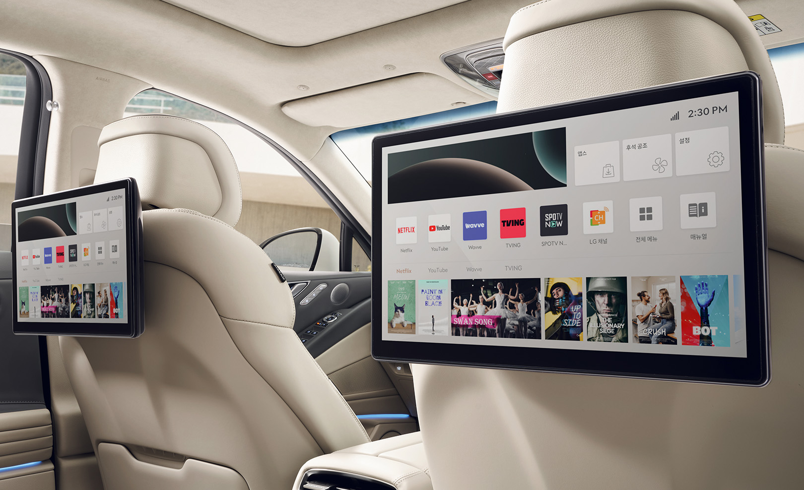 A dual monitor attached to the front seat, seen from the second row.