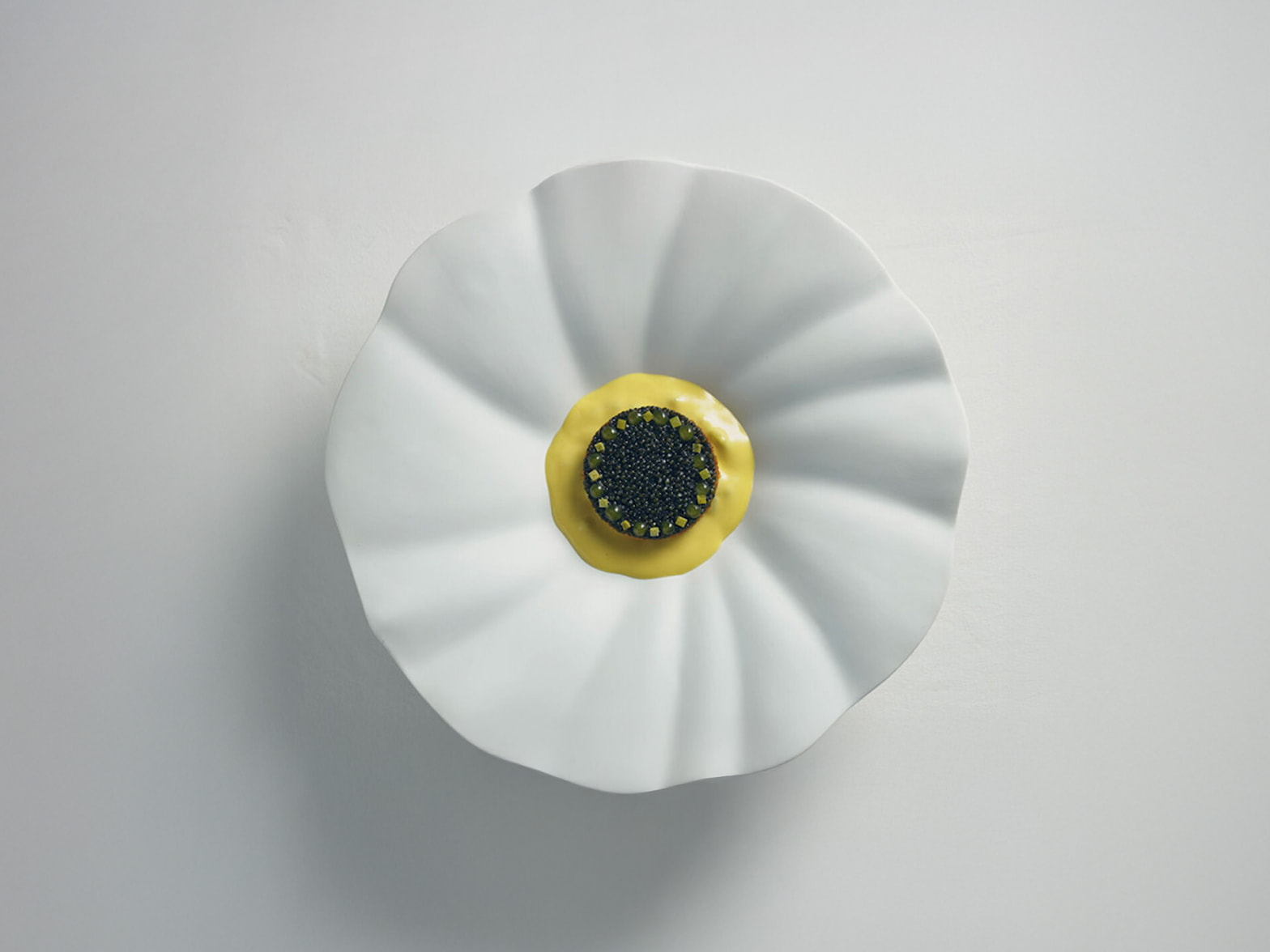 A Michelin-starred restaurant dish, specially prepared for G90 Long Wheel Base Black owners, is displayed. A luxurious black caviar dish with yellow sauce is plated on a white dish resembling a blooming flower.