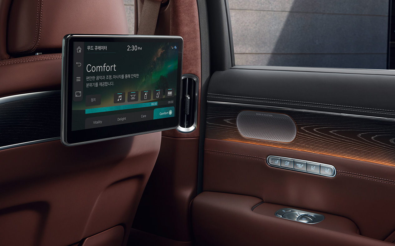 Orange lights are illuminated on the second row dual monitors and the vehicle door inside Bordeaux Brown interior.