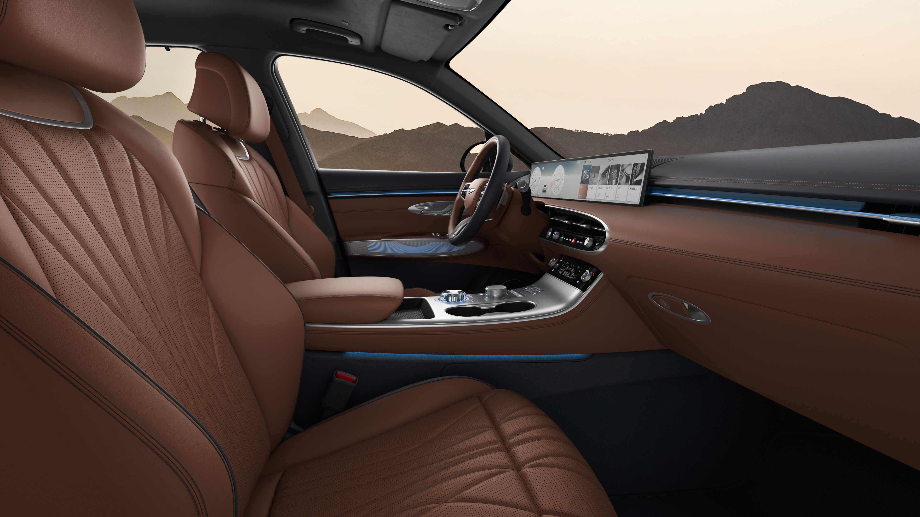 You can see the driver's seat of the GV70 with a two-tone color combination of Ocean Wave Blue and Havana Brown. The view is from the passenger seat, and there's a subtle blue mood lighting.