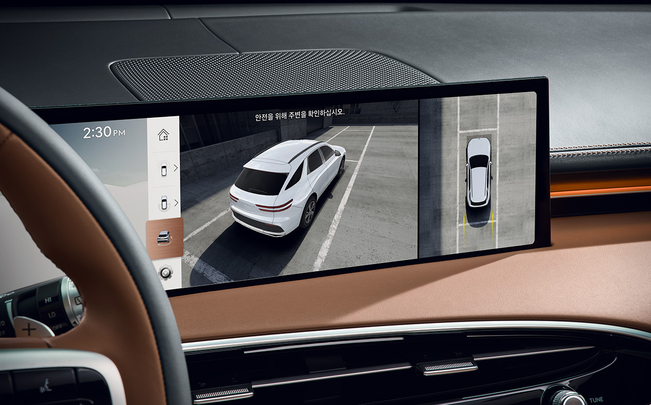 Screens showing the parked GV70 from various angles are split on the wide display.