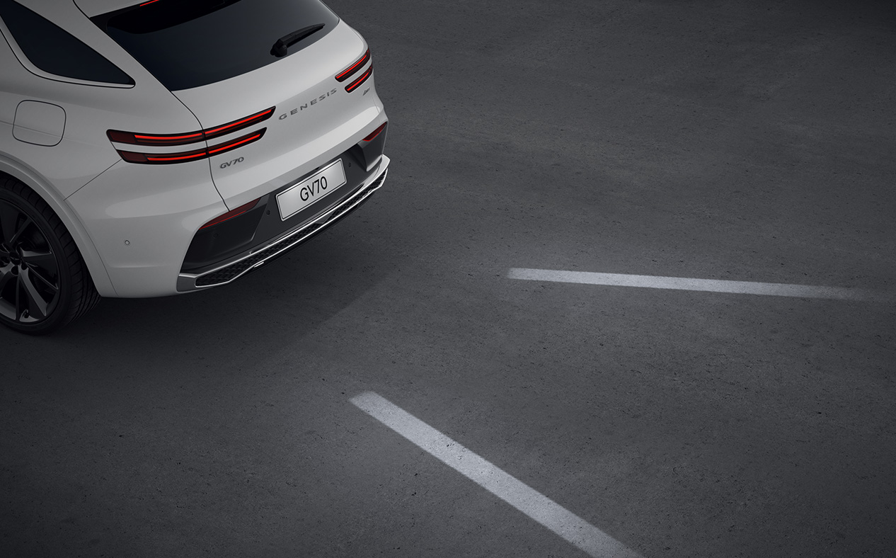The reversing GV70 is illuminating the road behind it with its lights.