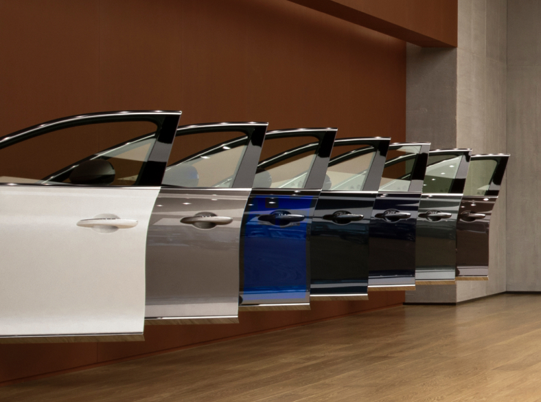 Genesis vehicle door samples are lined up on a wall made of weathered steel.
