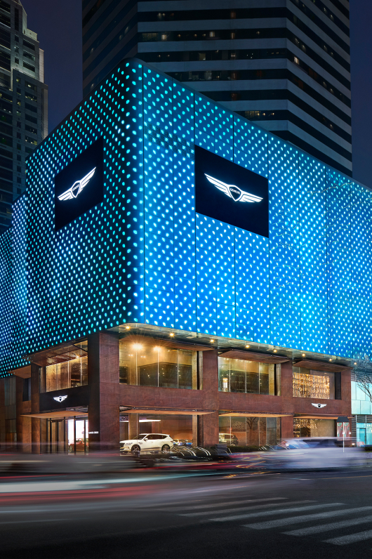 An exterior view of the house-inspired Genesis Studio Chengdu building. Through the glass windows, Genesis GV80 is seen on display.
