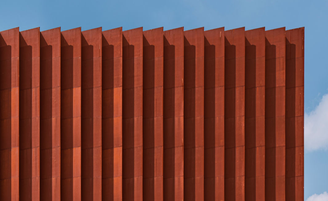 An exterior view of Genesis Suji in Korea, made with weathered steel.