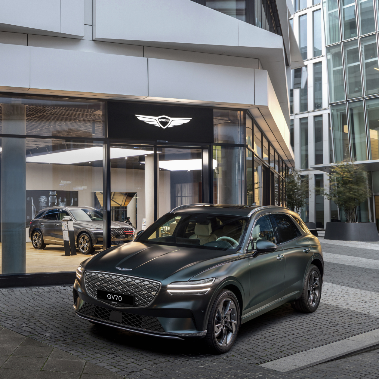 Genesis GV70 is parked in front of the Genesis Studio Frankfurt building in Germany.